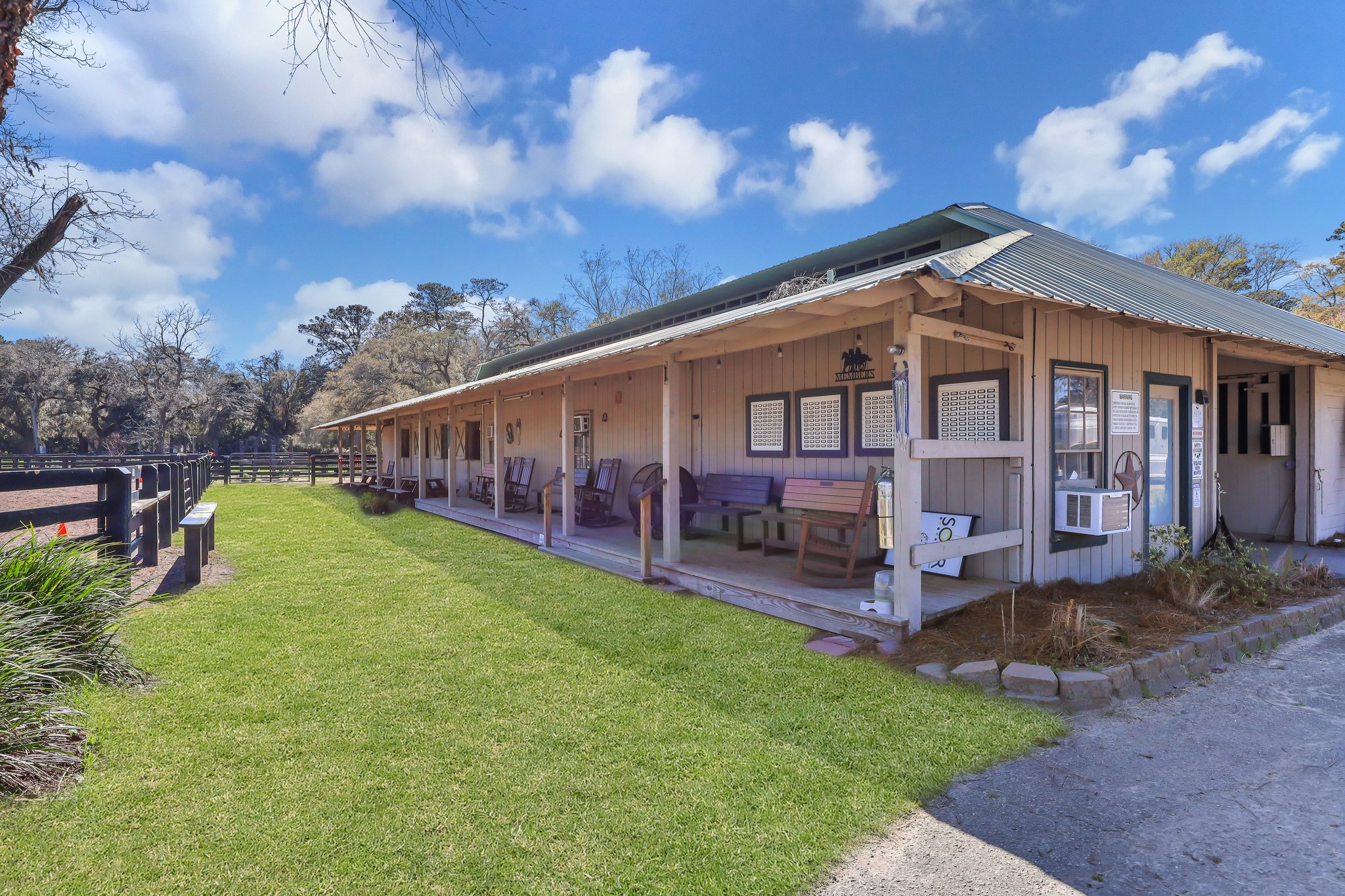 Front view of 4 Spartina Point Drive in Moss Creek, a Kermitt Huggins–designed home with contemporary stucco exterior and marsh backdrop – listed by Allison Cobb of The Cobb Group eXp Luxury Realty.